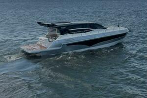 2025 Real 40 HT Luxury yacht cruising on a calm sea under a partly cloudy sky.