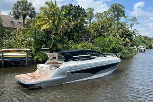 2025 Real 40 HT Luxury yacht cruising on a scenic river with lush greenery.