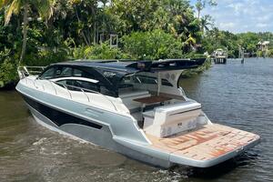 Luxury Real 40 HT yacht cruising on a scenic river, surrounded by lush greenery.