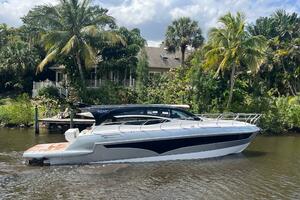 2025 Real 40 HT Luxury yacht cruising on a tropical river with lush greenery.