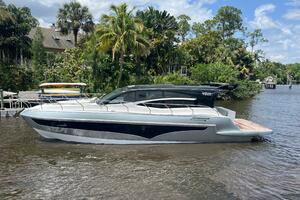 Luxury 2025 Real 40 HT yacht on a scenic river with lush greenery.