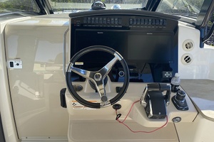 Cockpit of 2023 Boston Whaler 350 Realm with steering wheel and control panel.