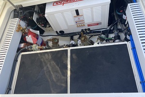 Engine compartment of 2023 Boston Whaler 350 Realm with generator and fire extinguisher.